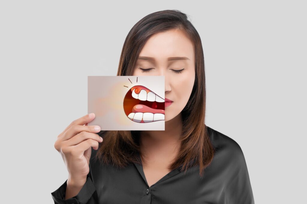 Asian lady holding a drawing of inflamed tooth before her face