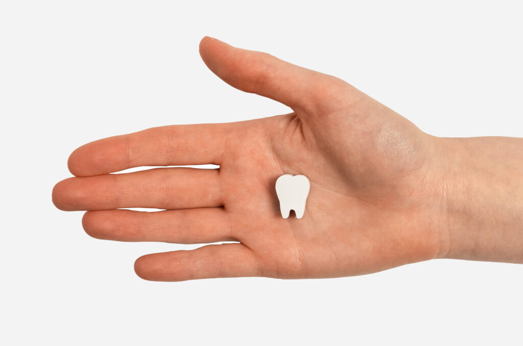 Artificial tooth on a hand