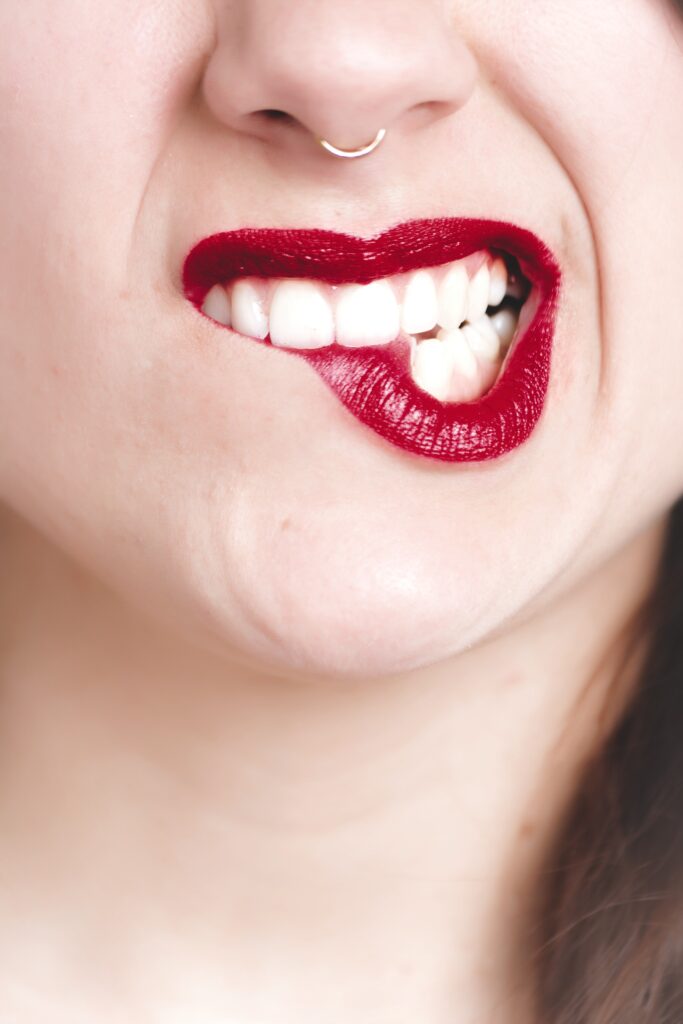 Ladys mouth with white teeth and red lipstick